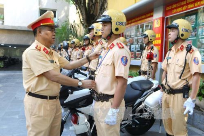 Đại tá Đào Vịnh Thắng, Trưởng phòng Cảnh sát giao thông Công an Thành phố Hà Nội chỉnh đốn trang phục chiến sỹ dẫn đoàn. Ảnh: Doãn Tấn/TTXVN